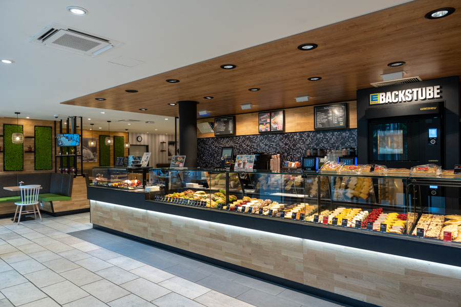 Moderne Bäckerei- und Cafétheke im Supermarkt mit einer Auswahl an frischen Backwaren