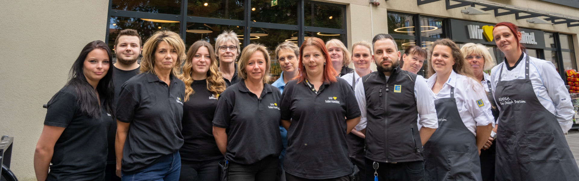 Das Team von EDEKA Hannemann steht vor dem Marktgebäude und blickt in die Kamera