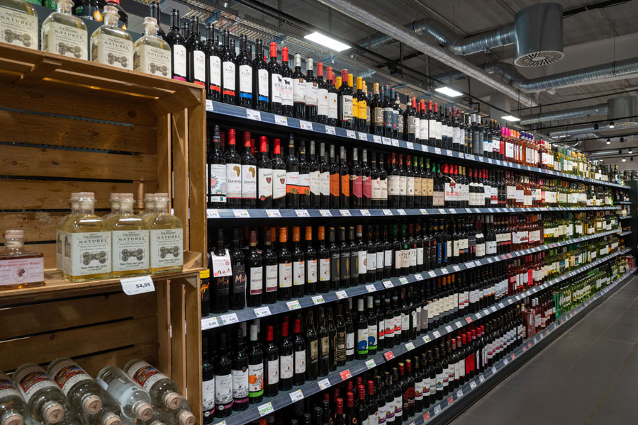 Getränkeabteilung im Supermarkt mit großer Auswahl an Weinflaschen und Spirituosen